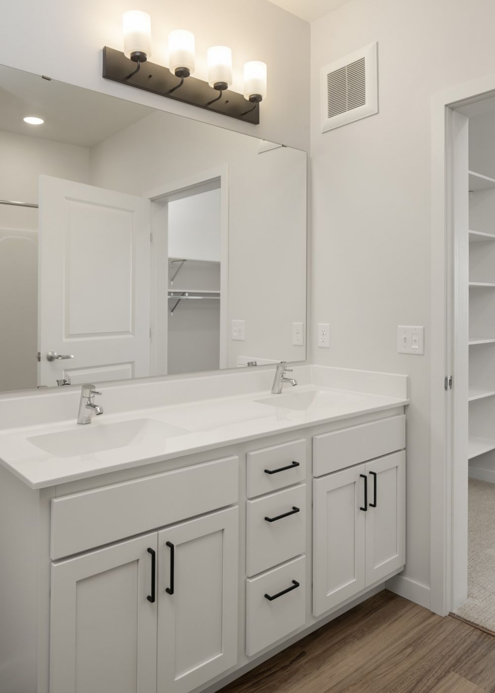Aster apartments bathroom light finish palette with wood-look LVP flooring and lots of cabinetry for storage