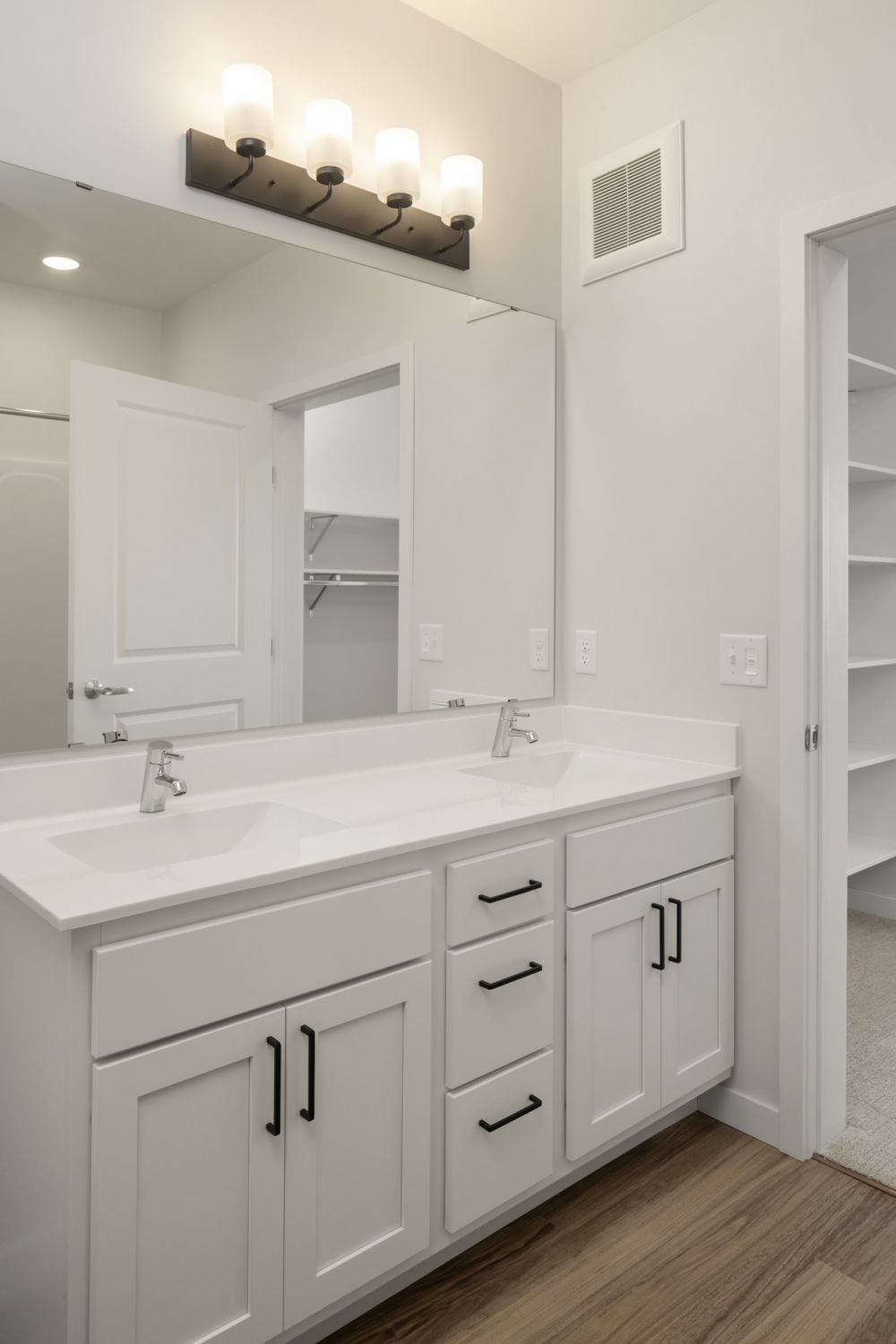 Aster apartments bathroom light finish palette with wood-look LVP flooring and lots of cabinetry for storage