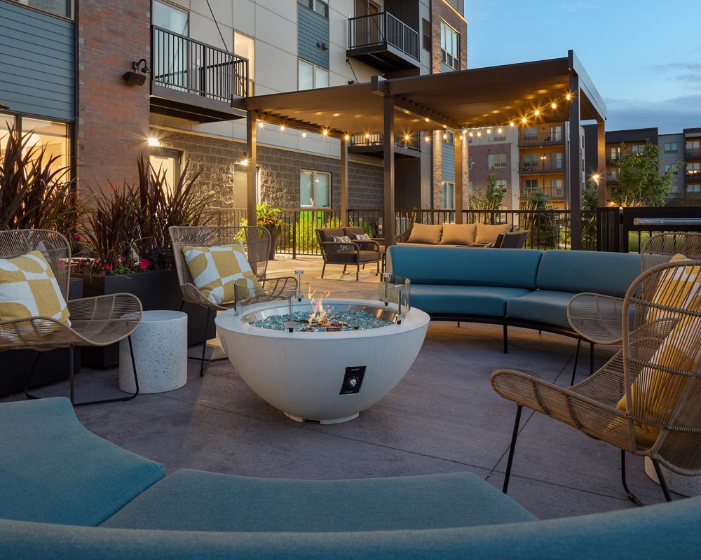Outdoor lounge with couches, string lights and fire pit