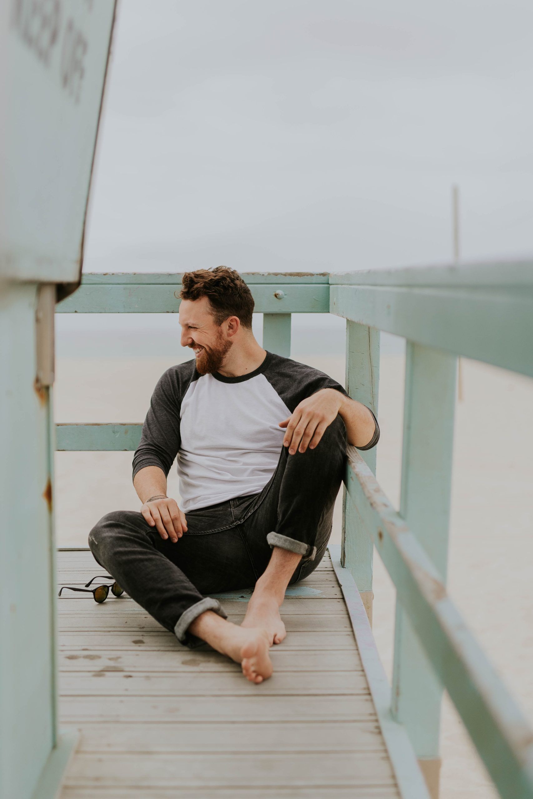 Man smiling sitting on boardwalk